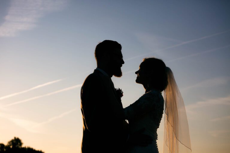Silhouettenfoto in der Abendsonne mit Brautschleier.