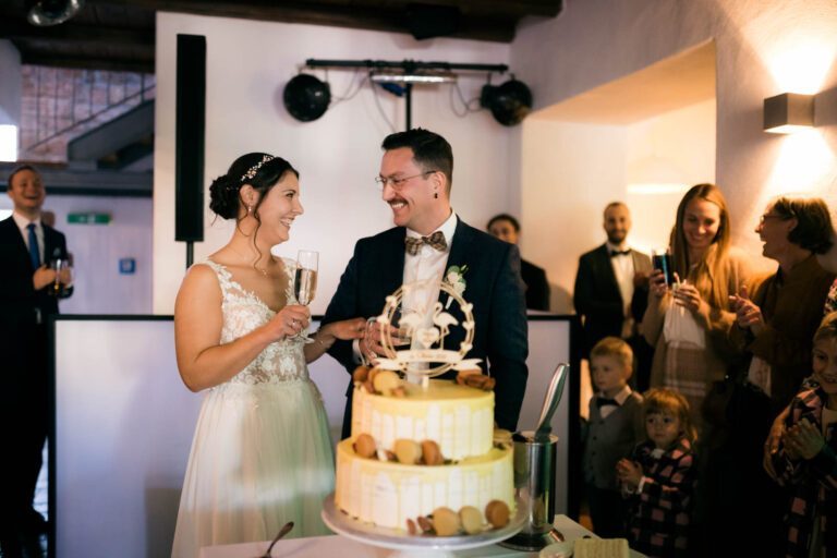 Anschnitt der Hochzeitstorte durch das Brautpaar in der Eventgalerie auf dieser Herbsthochzeit
