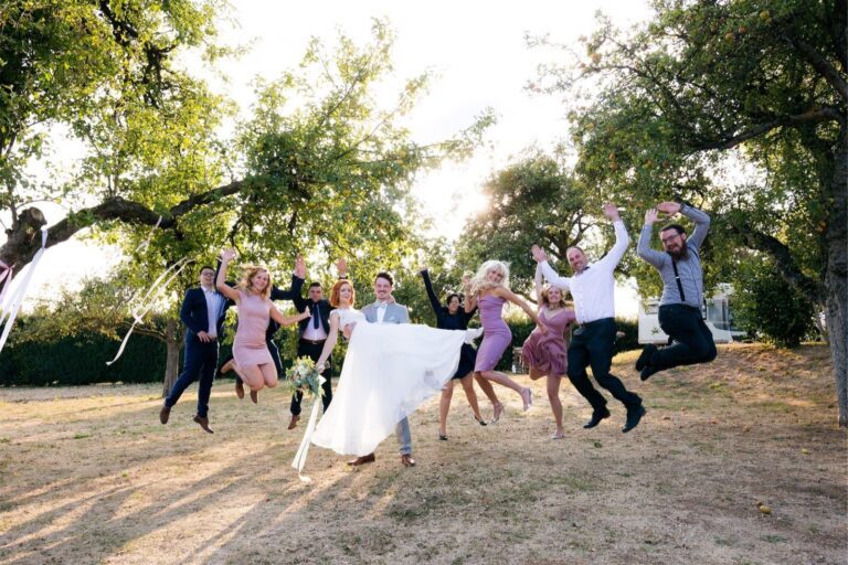 Gäste auf der Hochzeit des Alten Obstkellers Mönchberg posieren für ein Gruppenfoto auf den Streuobstwiesen.