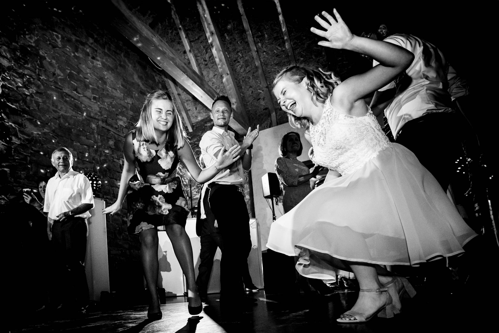 Glückliche Gäste auf der Tanzfläche: Lebendige Reportagefotografie, die die Begeisterung und das Tanzen der Hochzeitsgäste einfängt.