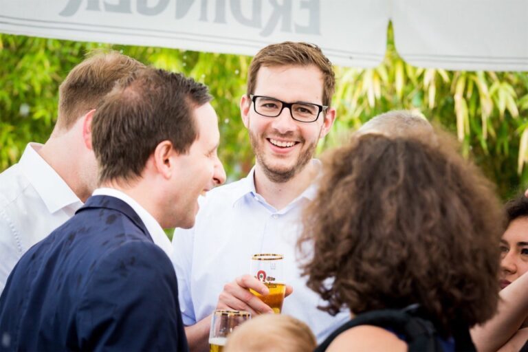 Fröhliche Hochzeitsgesellschaft vor dem Hofgut: Lebhafte Aufnahmen der ausgelassenen Stimmung der Gäste.