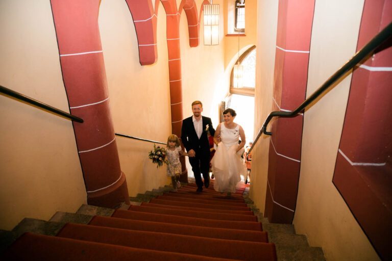 Braut und Bräutigam gehen die Hochzeitstreppe zum Trausaal der Mainmetropole hoch.