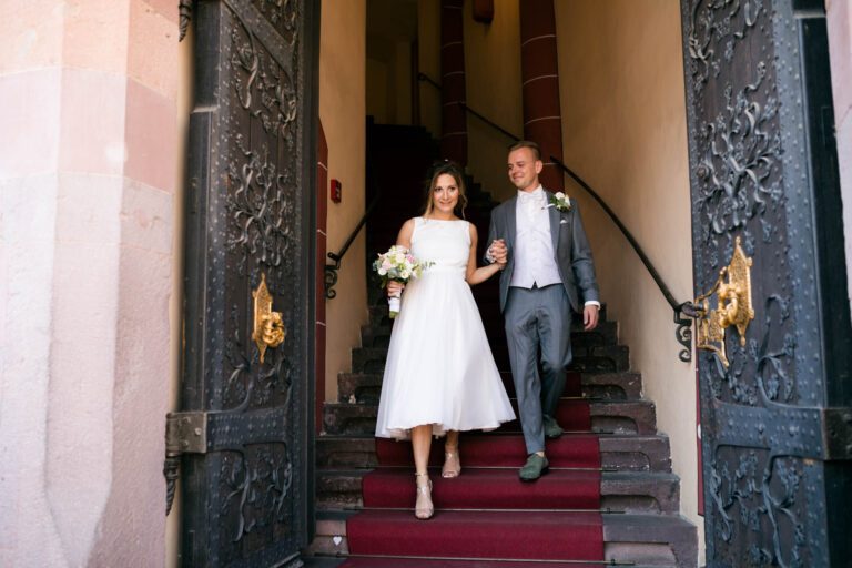 Braut und Bräutigam gehen die Hochzeitstreppe hinab.