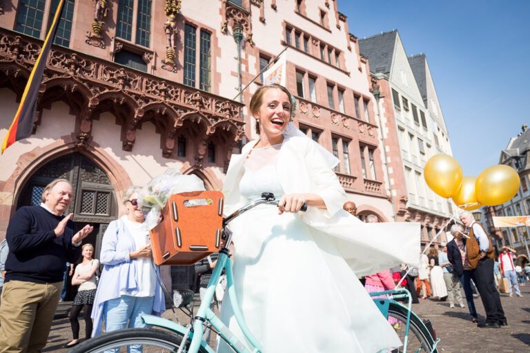 Die Braut kommt mit ihrem Fahrrad zur standesamtlichen Hochzeit am Römer Frankfurt.